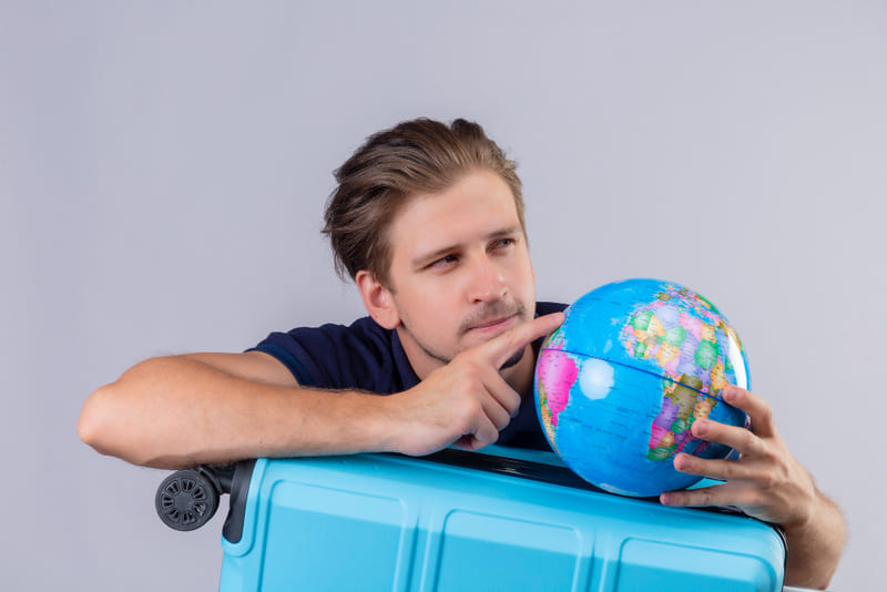 chico joven sosteniendo bola del mundo